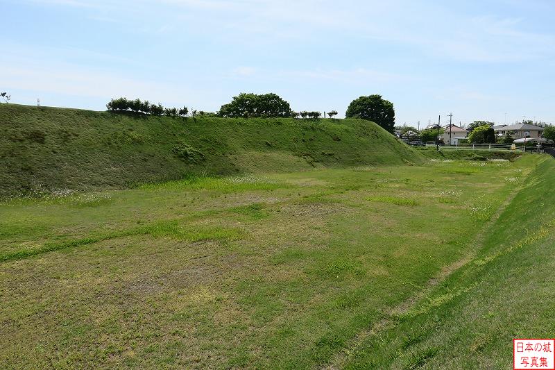 小田城 本丸北西隅・遺構展示室 本丸北側の堀越しに本丸土塁を見る。堀はかつては障子堀と呼ばれる構造であった