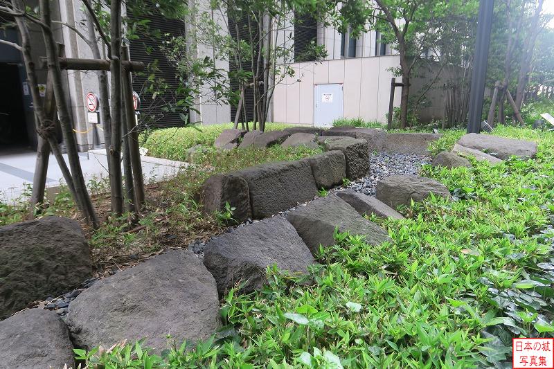 江戸城 北町奉行所跡 文化3年(1806)から当地に北町奉行所が置かれた。「遠山の金さん」で知られる遠山景元もここで執務した。発掘調査で奉行所の遺構が発見され、現在展示されている石組は約30m西から発見された下水溝である。本来は3～4段の石積みであったが現在は最下段のみが残る。