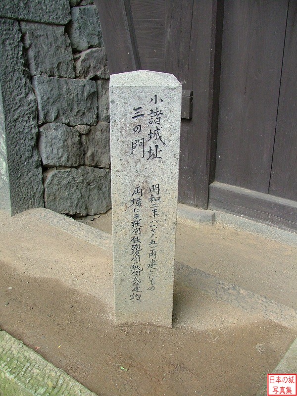 石碑「小諸城址三の門　明和二年(1765)再建したもの。両塀に矢狭間、鉄砲狭間の戦闘式建物」とある