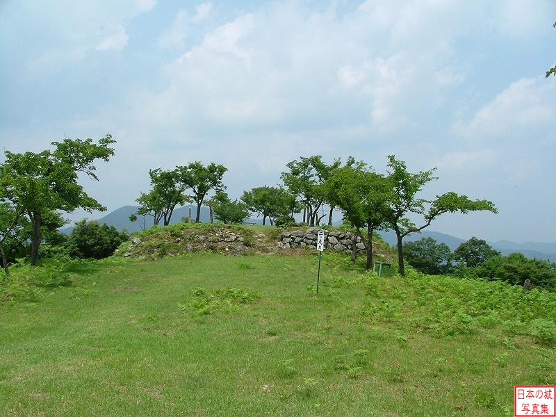 黒井城 山頂 二の丸跡。向こうに本丸石垣が見える。二の丸には木が茂っている訳でもなく平坦地が広がる。